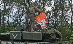 Rușii arborează pe un tanc un steag al URSS cu chipul lui Stalin pe el